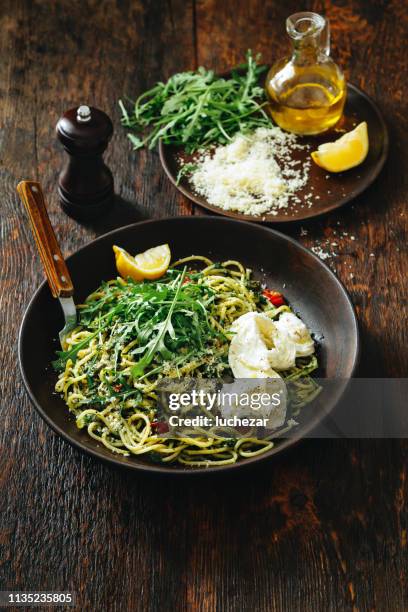 spaghetti au pesto, tomates rôties, roquette fraîche et mozzarella - pistou photos et images de collection