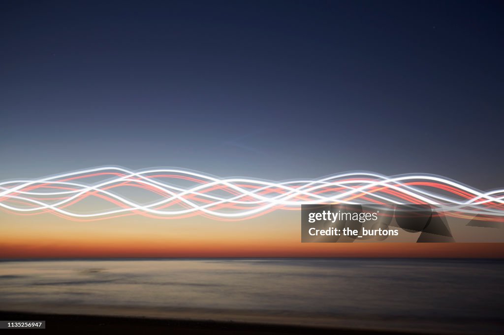Light waves at beach during sunset (light painting)