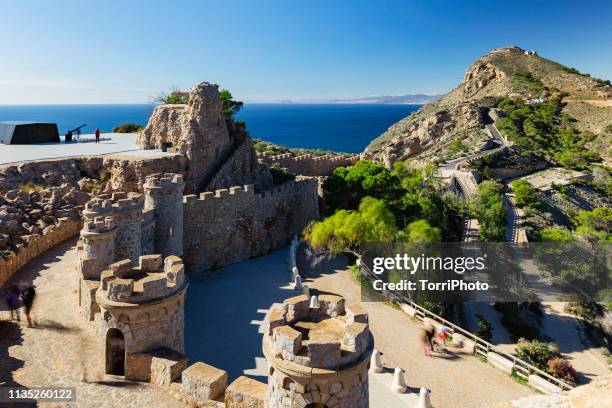 bateria de castillitos - the watchman battery, fortified building with crenelated towers and stone walls in the mountains on the seacoast. cartagena, murcia, spain - murcia - fotografias e filmes do acervo