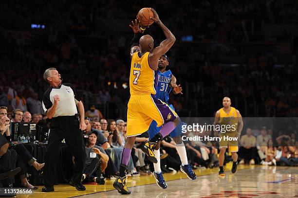 Lamar Odom of the Los Angeles Lakers shoots the ball from beyond half court as Jason Terry of the Dallas Mavericks is called for a foul by referee...