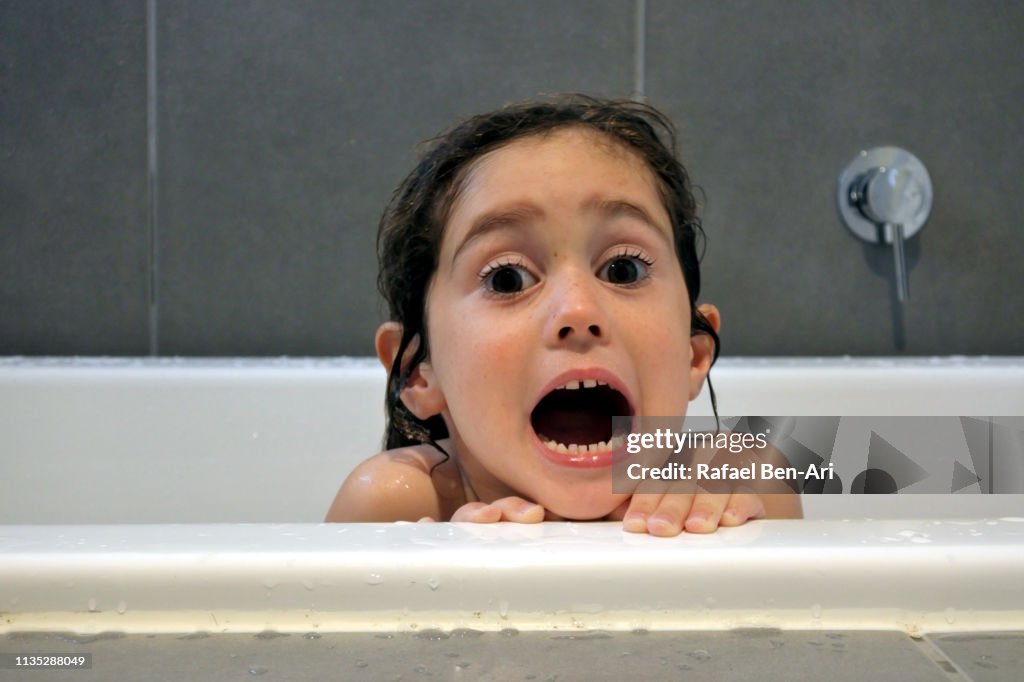 Afraid young girl having a bath