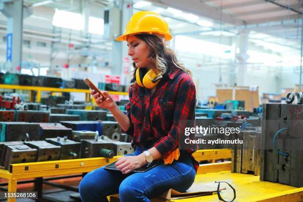 portrait of factory female employee using smartphone - frustrated workman stock pictures, royalty-free photos & images