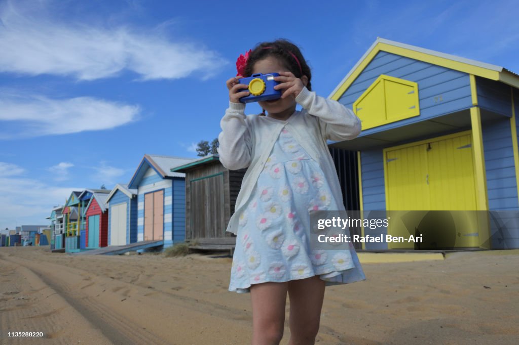 Young girl photographing the Iconic Bathing Boxes of the Mornington Peninsula Victoria Australia