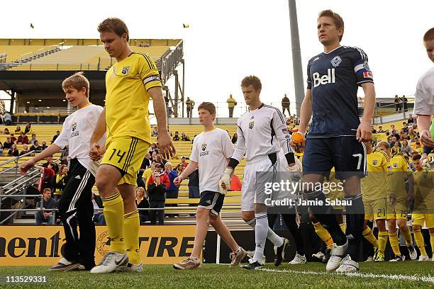 Captains Chad Marshall of the Columbus Crew and Terry Dunfield of the Vancouver Whitecaps FC lead their teams on to the field on April 30, 2011 at...