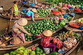 Vietnamese women selling fruits on floating market, Mekong River Delta, Vietnam