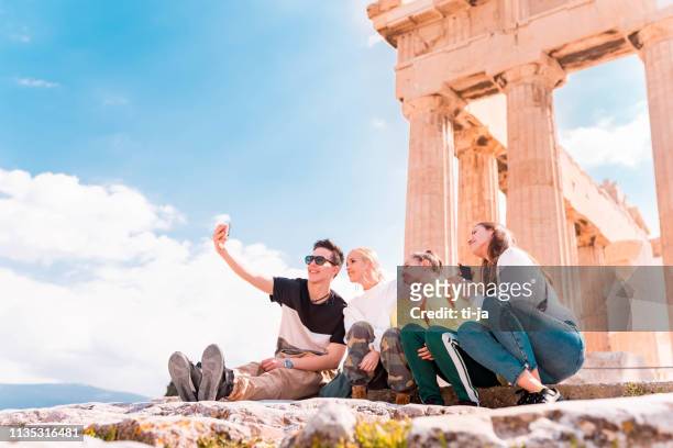 group of young tourists in acropolis - athens - athens stock pictures, royalty-free photos & images