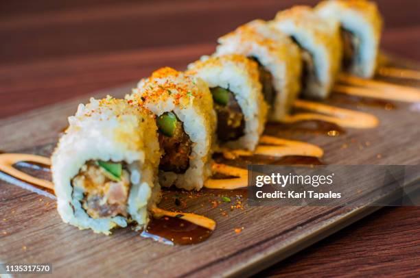 a high-angle and close-up view of freshly made tuna sushi - hand roll stock pictures, royalty-free photos & images