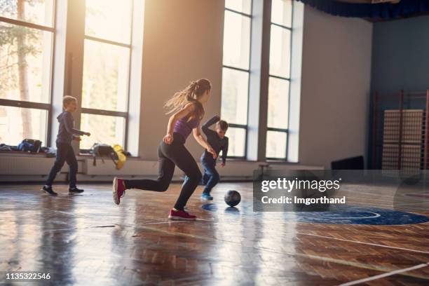 kids playing football in the school gym - educational facility stock pictures, royalty-free photos & images