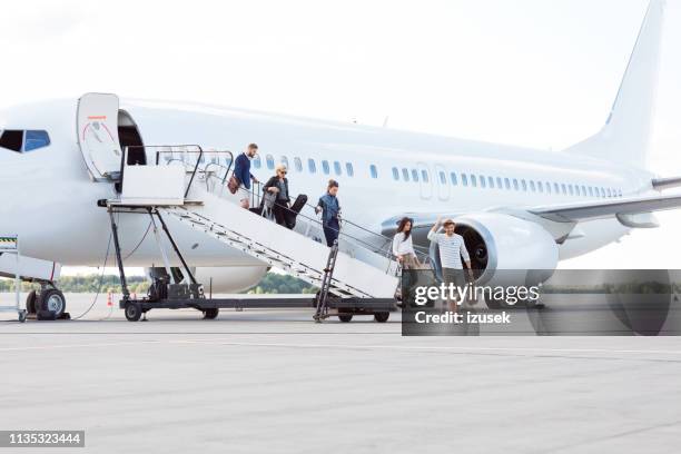 people getting off an airplane - jet tarmac stock pictures, royalty-free photos & images