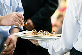 a server holding a tray full of snacks during a catered event