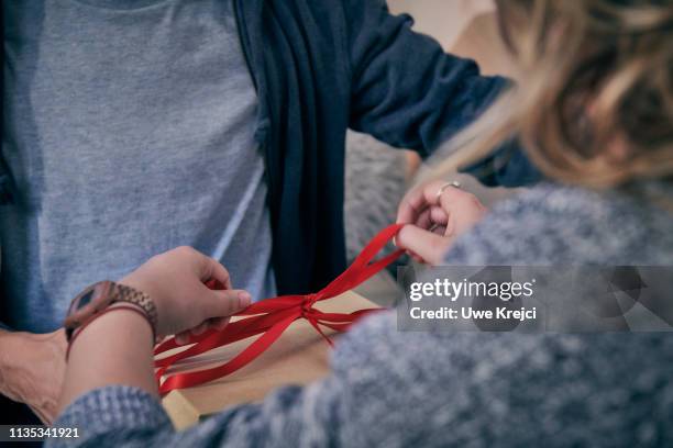 couple preparing gift - lint strik stockfoto's en -beelden