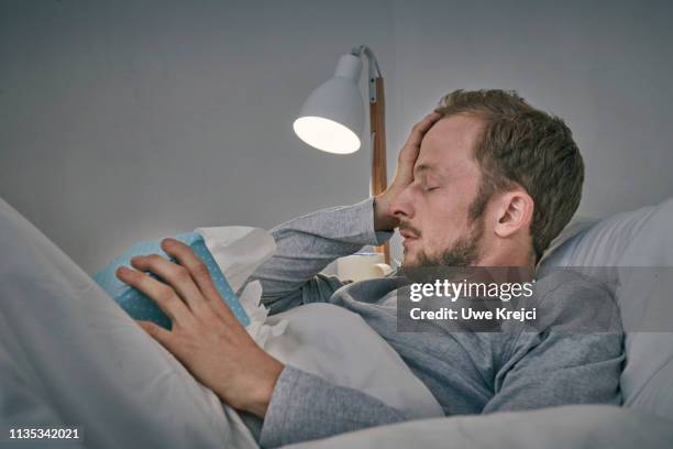 sick man in bed - man headache bildbanksfoton och bilder