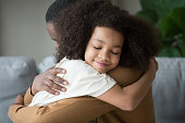 Cute mixed race child daughter embracing father feeling love connection