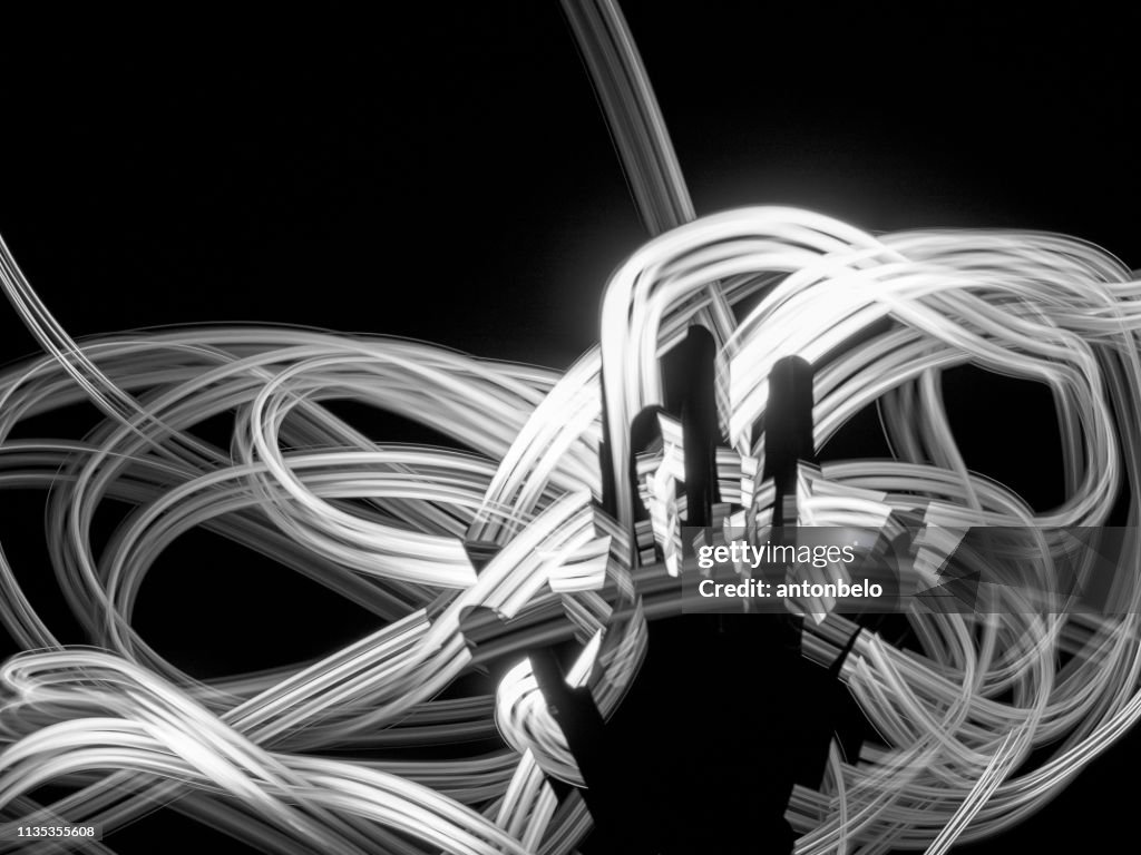 Hand silhouette against white light lines abstract background. Nerves, energy, meditation concept. Futuristic glowing path