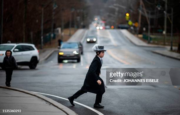 This picture taken on April 5, 2019 shows a boy crossing a the street in a Jewish neighborhood of Monsey, Rockland County, New York. - A measles...