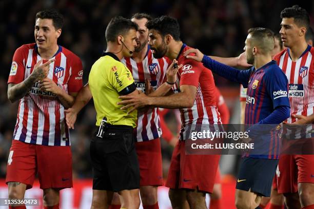 Atletico Madrid's Spanish forward Diego Costa talks with Spanish referee Gil Manzano prior to receiving a red card during the Spanish league football...