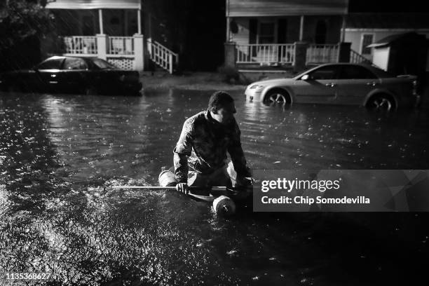 Michael Nelson floats in a boat made from a metal tub and fishing floats after the Neuse River went over its banks and flooded his street during...