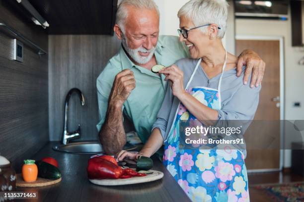 野菜を食べるカップル - middle aged couple cooking ストックフォトと画像