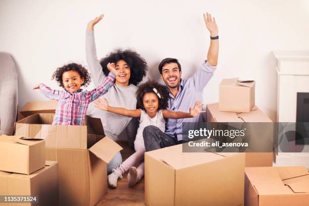 young happy family moving into a new house. - two kids with cycle imagens e fotografias de stock