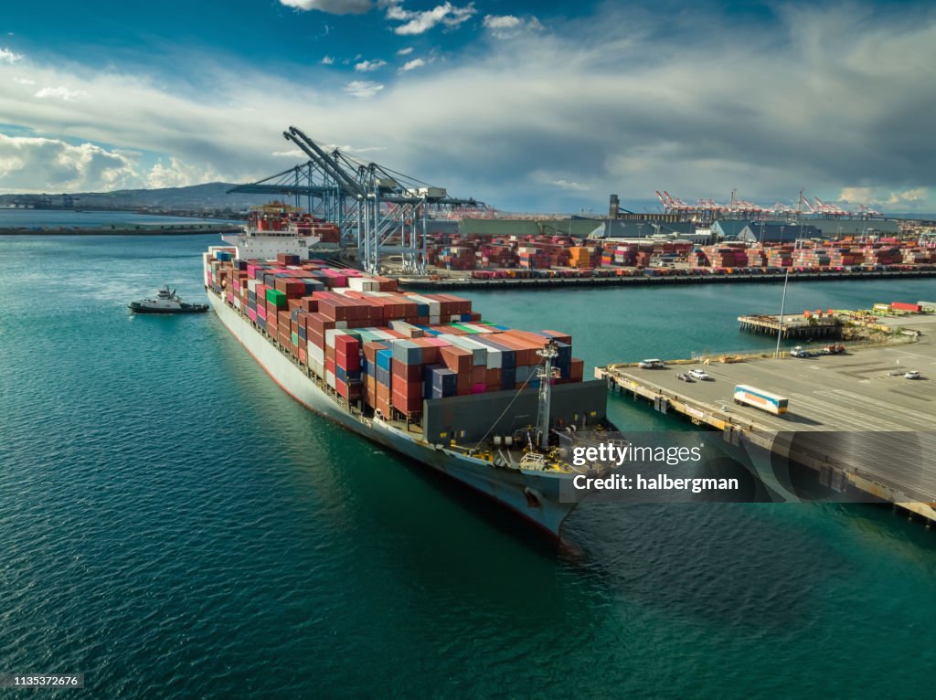 Schlepper manövrieren Cargo-Schiff am Dockside in Port of Long Beach