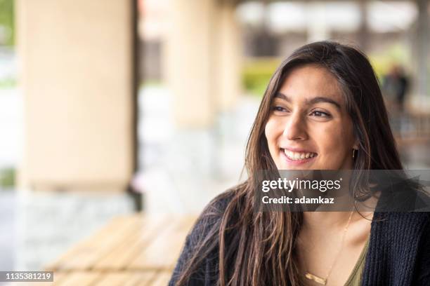 portret van een jonge vrouw buiten glimlachend - testimonial stockfoto's en -beelden