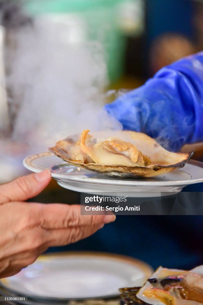 Serving a Hokkaido grilled scallop