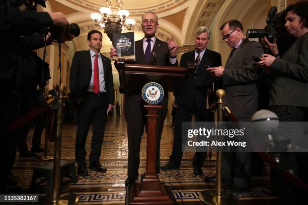 Senate Minority Leader Sen. Chuck Schumer holds up a copy of U.S. President Donald Trump's FY2020 budget request as Sen. Brian Schatz and Sen....