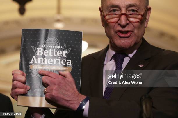 Senate Minority Leader Sen. Chuck Schumer holds up a copy of U.S. President Donald Trump's FY2020 budget request during a news briefing after the...