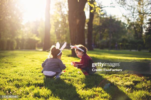 toddlers in easter egg hunt - easter stock pictures, royalty-free photos & images
