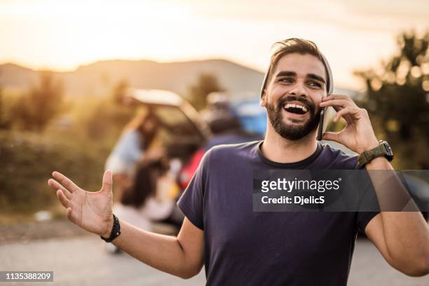 gelukkige jonge man praten op een telefoon, terwijl op een road trip met vrienden. - s the adventures of rin tin tin stockfoto's en -beelden