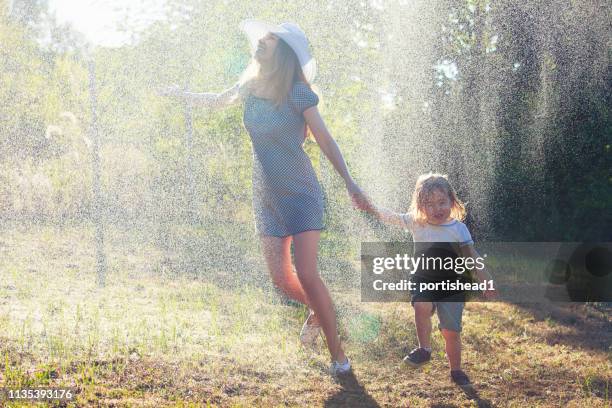 mutter und kind haben spaß im regen - girls in wet dresses stock-fotos und bilder