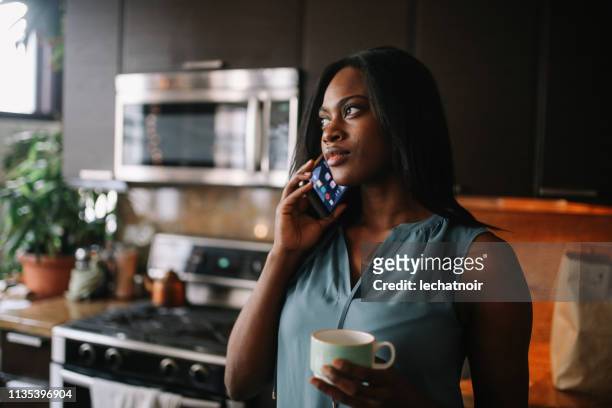 young woman having a morning coffee in her downtown los angeles apartment - talk phone flat imagens e fotografias de stock