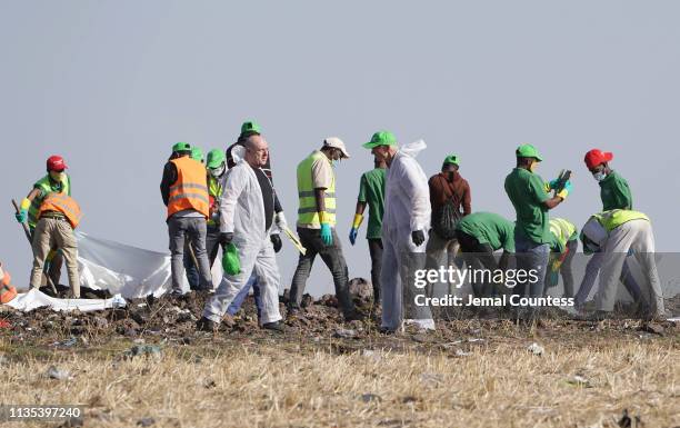 Forensics investigators and recovery teams collect personal effects and other materials from the crash site of Ethiopian Airlines Flight ET 302 on...