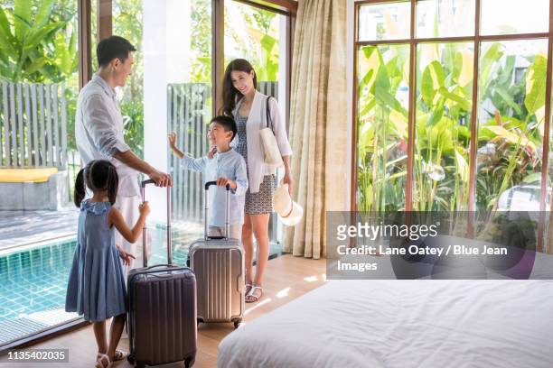 happy young family in hotel room - four people walking away stock pictures, royalty-free photos & images