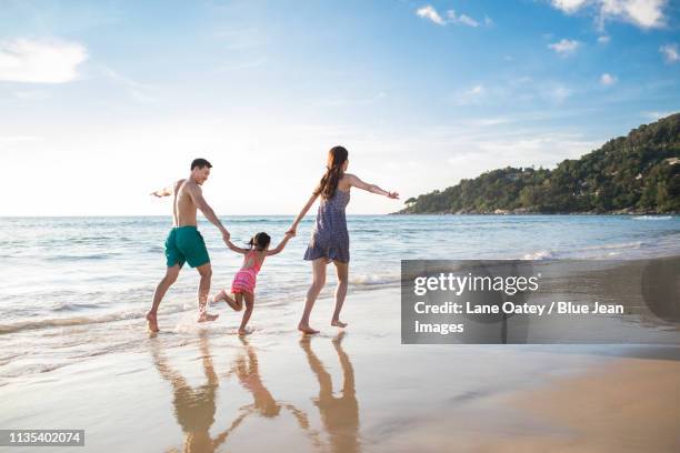 happy young family having fun on beach - tourist mother father child thailand stock pictures, royalty-free photos & images