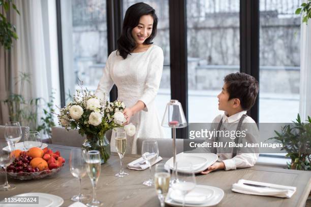 mother and son setting the table - fashionable mom stock pictures, royalty-free photos & images