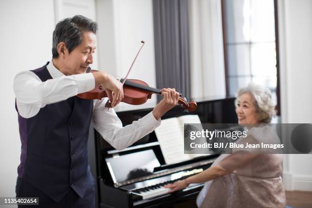 noble senior couple playing the piano and violin - violin family stock pictures, royalty-free photos & images