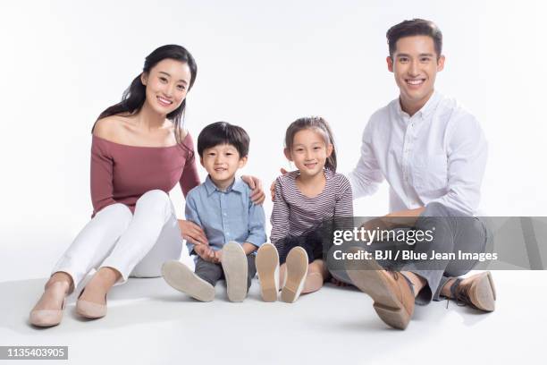 happy young family - front view portrait of four children sitting on rock stock-fotos und bilder