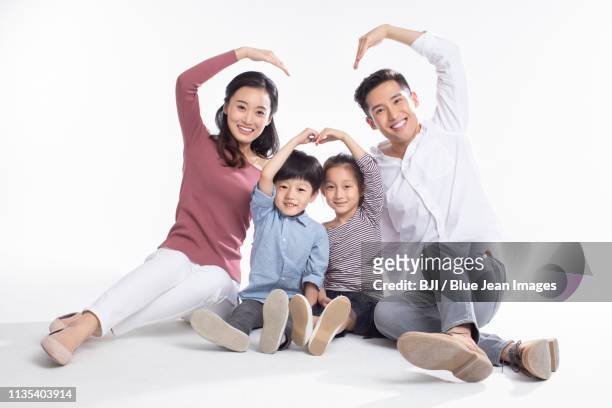 happy young family - front view portrait of four children sitting on rock stock-fotos und bilder