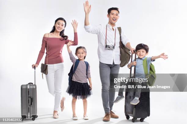 happy young family going on vacation - front view portrait of four children sitting on rock stock-fotos und bilder