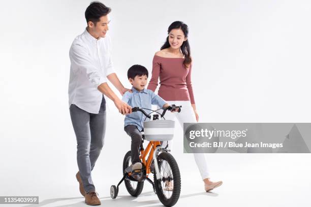 young parents teaching son to ride bike - couple walk white background stock pictures, royalty-free photos & images