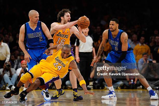 Kobe Bryant of the Los Angeles Lakers falls down as Pau Gasol looses the ball in front of Jason Kidd and Tyson Chandler of the Dallas Mavericks late...