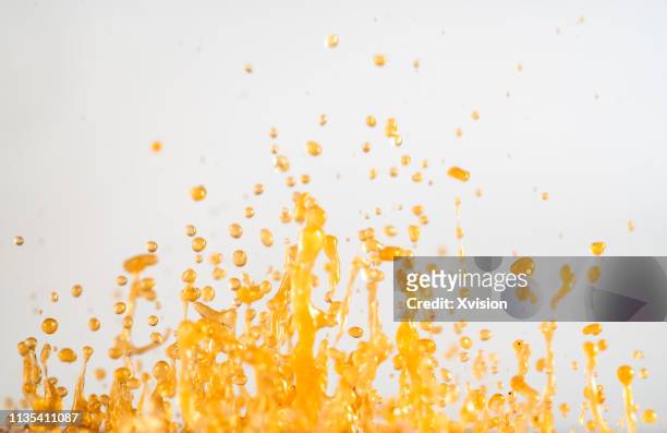 dancing golden powder color paint dye with white background - oil splashing stock pictures, royalty-free photos & images