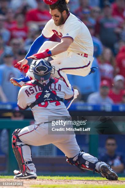 Bryce Harper of the Philadelphia Phillies attempts to score past Willians Astudillo of the Minnesota Twins but is tagged out in the bottom of the...