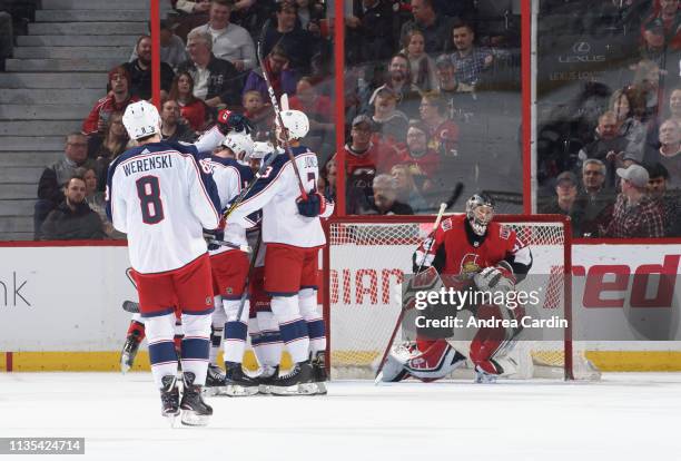 Pierre-Luc Dubois of the Columbus Blue Jackets celebrates with teammates Zach Werenski and Seth Jones after scoring his second goal of the period...