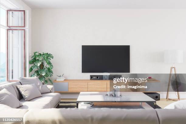 moderne, lichte en luchtige woonkamer - tv on wall stockfoto's en -beelden