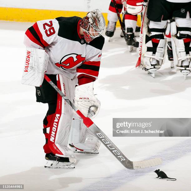 Goaltender Mackenzie Blackwood of the New Jersey Devils pokes a plastic rat wit his stick after their 4-3 overtime win over the Florida Panthers at...