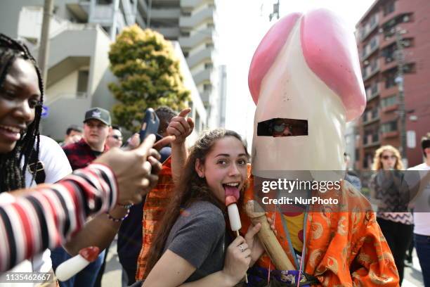 Image contains graphic content.)Festival goer takes photo with phalluse shape mask during the annual Kanamara Matsuri in Kawasaki, Japan on April 7,...
