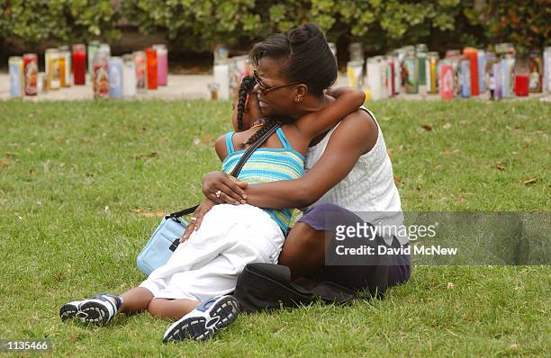 Cassandra Webster and her 9-year-old daughter Myieh share a tearful hug near a makeshift shrine for slain 5-year-old Samantha Runnion July 19, 2002...