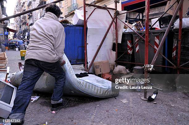 Man moving a mattress by a pile of uncollected rubbish a Forcella near the Catherdal of Naples on May 2, 2011 in Naples, Italy. Italy's third largest...